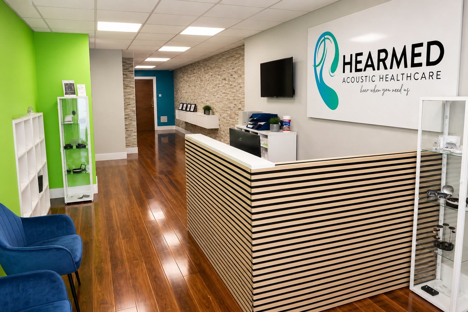 HearMed clinic reception with the HearMed Acoustic Healthcare sign above the desk